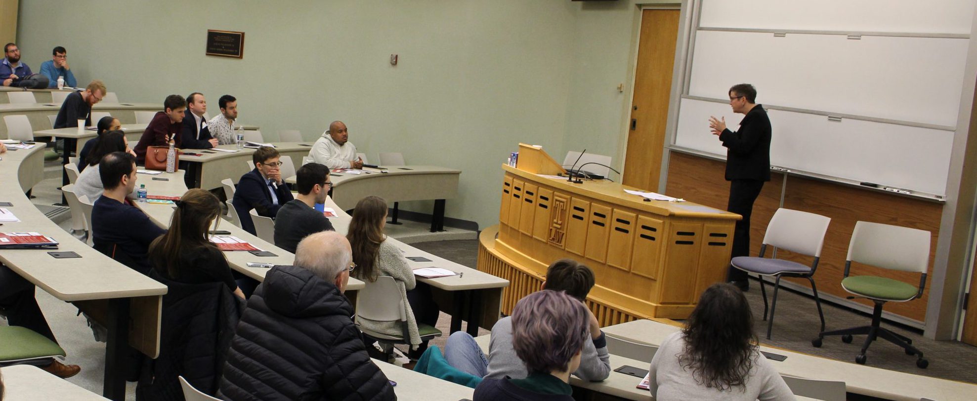 Prof. Carpenter speaks to a lecture hall with seated students