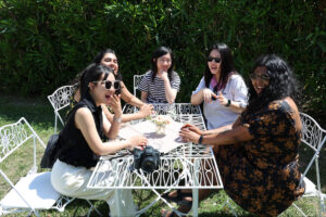 Xin Lyue and a group of friends smiling while sitting at a table together in Rome